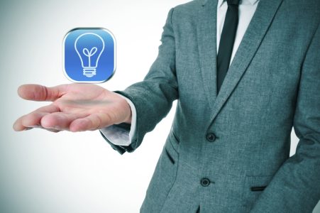 man wearing a suit with an icon with a light bulb in his hand