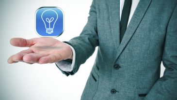 man wearing a suit with an icon with a light bulb in his hand