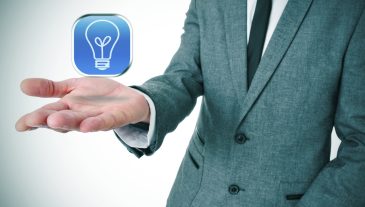 man wearing a suit with an icon with a light bulb in his hand