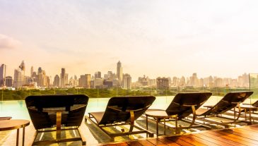 Chair around outdoor swimming pool with city view - Vintage Filter