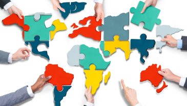Diverse Business People's Hands with Cartography Puzzle