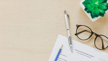 Top view business office desk background.The applying for a job form and pen pencil eyeglasses tree on wooden table background with copy space.