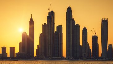 View of Dubai with sun at sunrise, UAE.